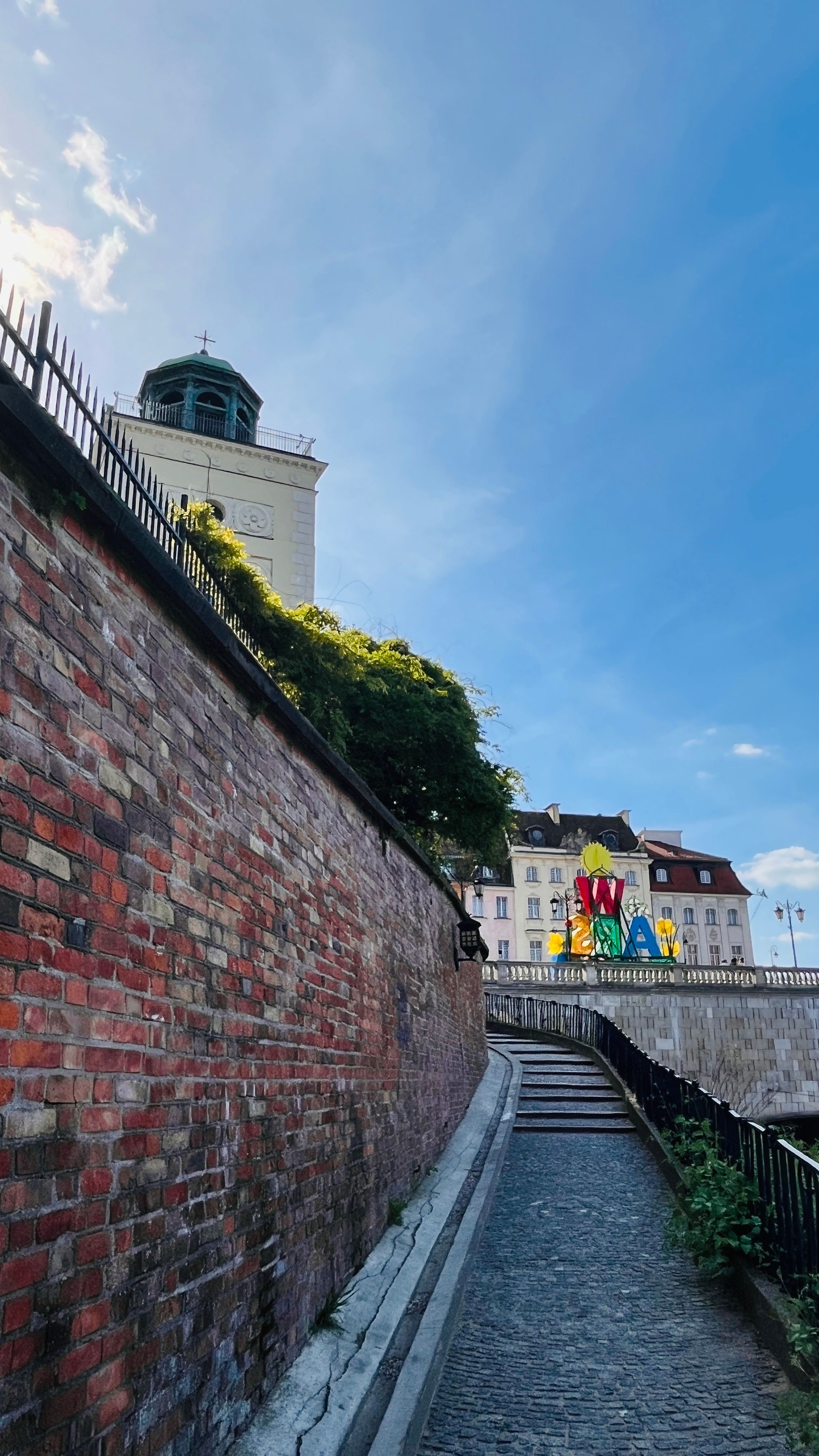 Beautiful brick pathway under a clear sky in a historic European cityscape.