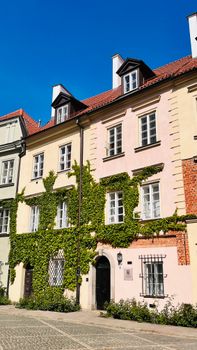 A picturesque ivy-covered house facade showcasing historic architecture on a sunny day.