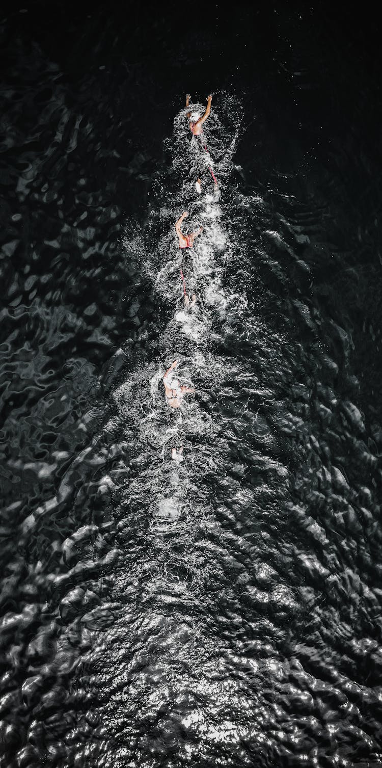 People Swimming Fast In Splashing Water