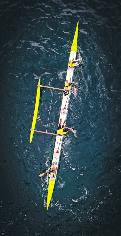 Free Drone view of sportive people resting on racing shell before rowing in sea Stock Photo