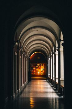 Dramatic lighting illuminates an arched hallway in Wrocław, with artistic wall displays.