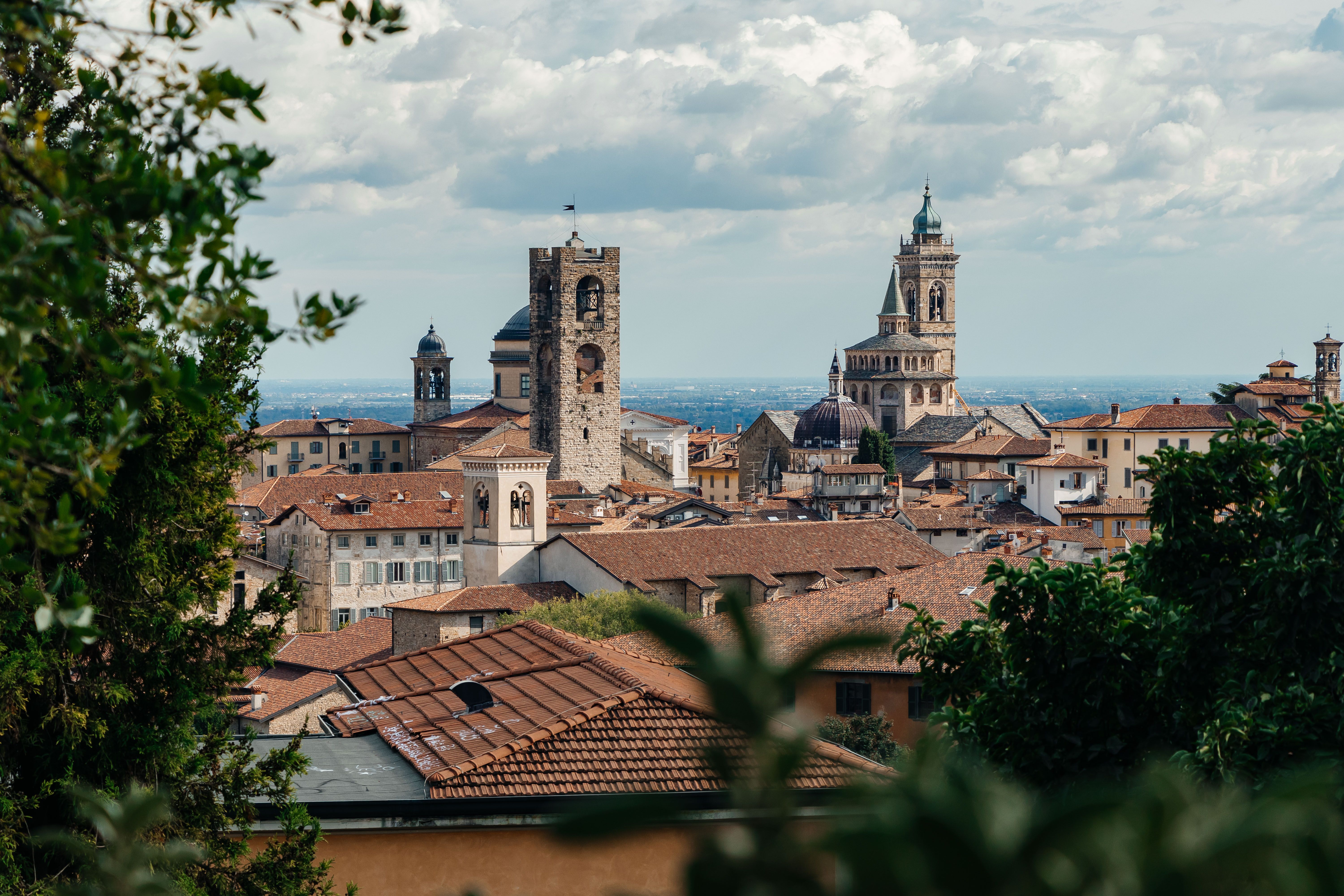 A picturesque view of Bergamo's historic skyline showcasing medieval architecture under a vibrant sky.