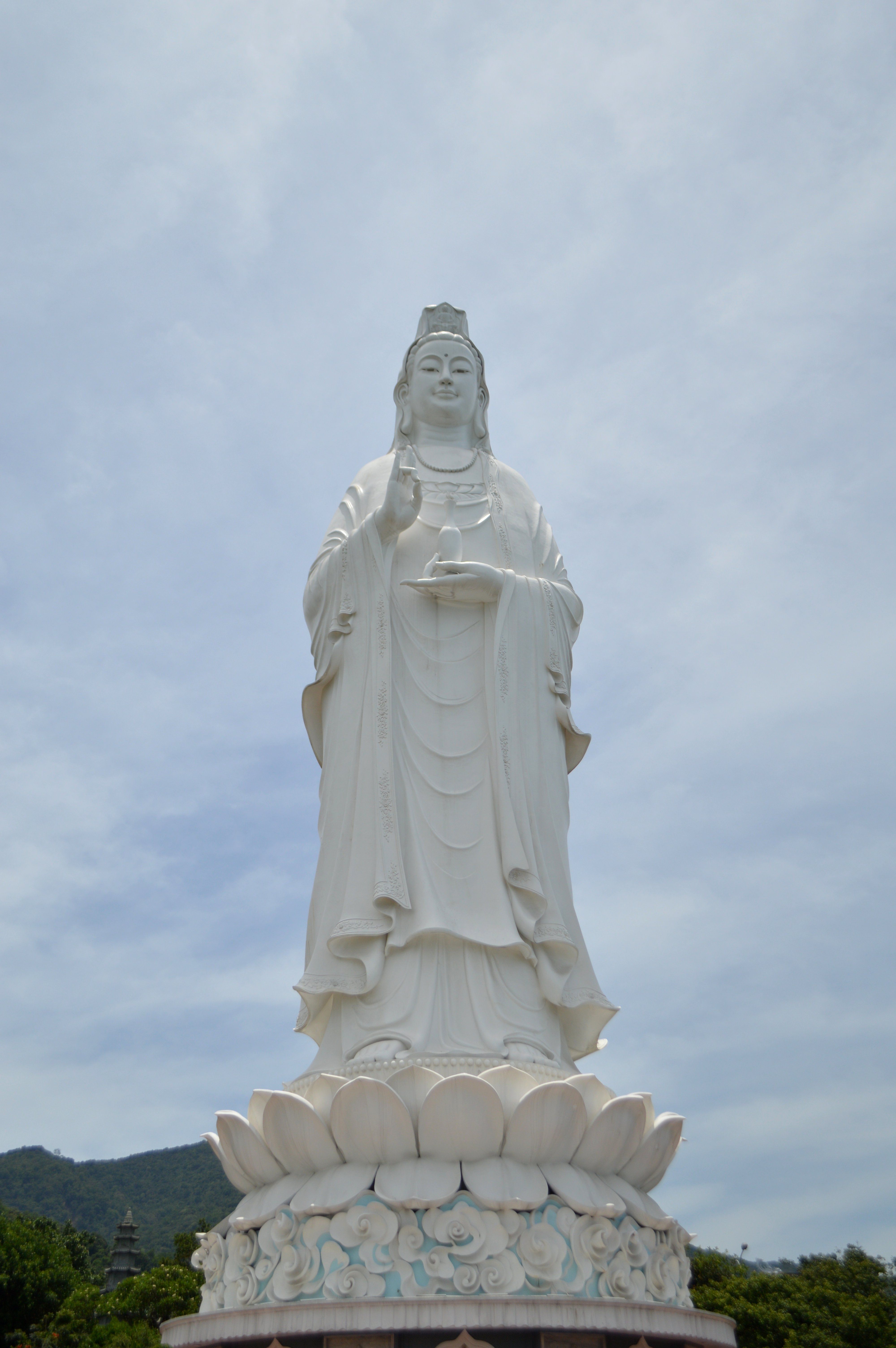 A serene Buddha statue stands gracefully against a clear sky in Da Nang, Vietnam.