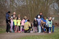 Group of children and adults gather outdoors preparing for a race or sporting event.
