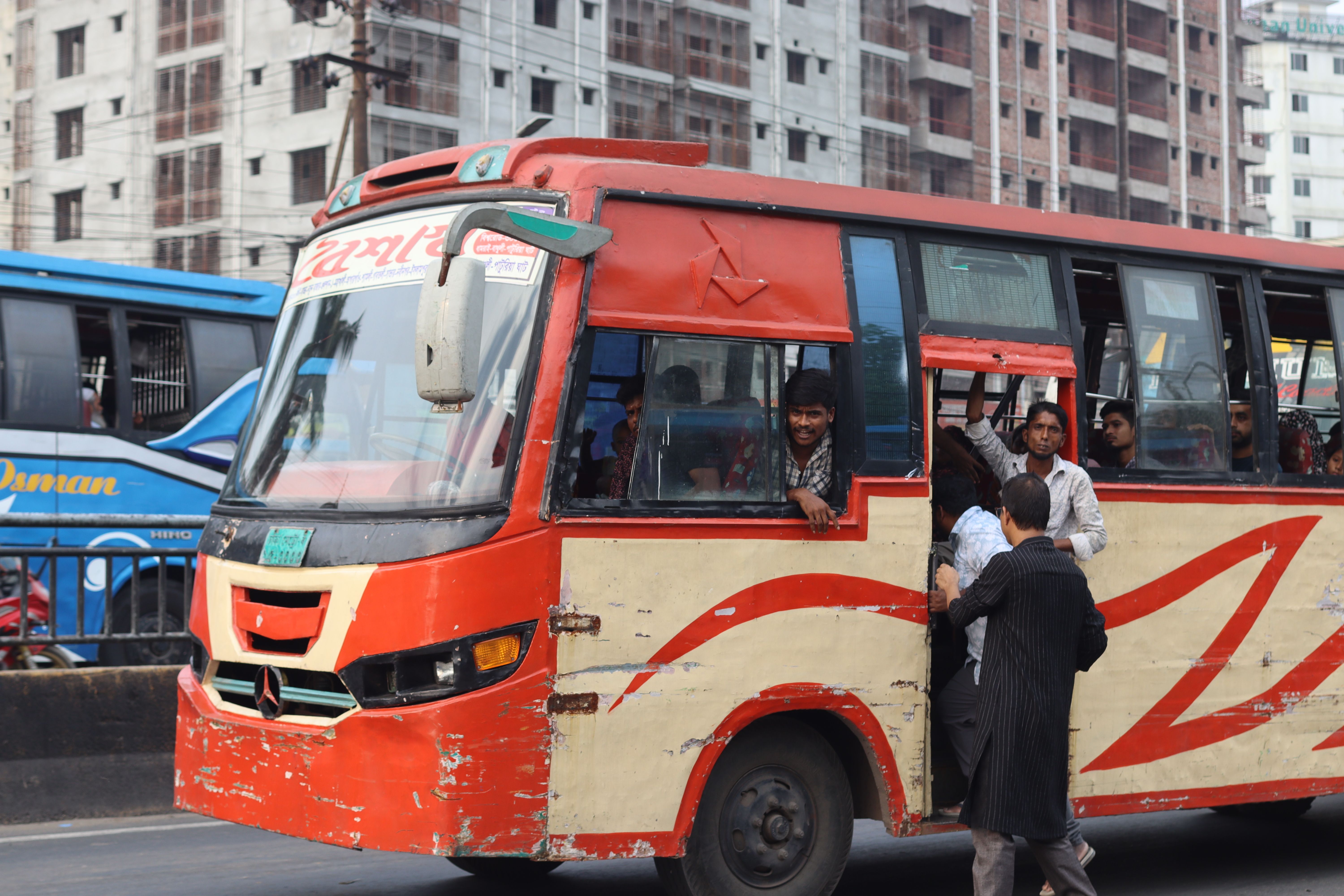 A bustling urban scene with a packed public bus on a busy city street.