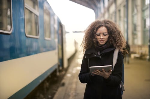 Woman in Black Coat Holding White Tablet Computer