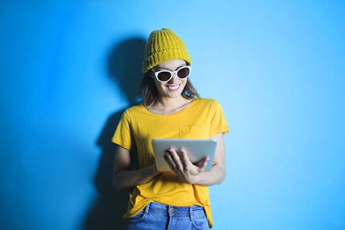 Woman in Yellow shirt Leaning Against Blue Wall