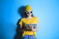 Woman in Yellow shirt Leaning Against Blue Wall