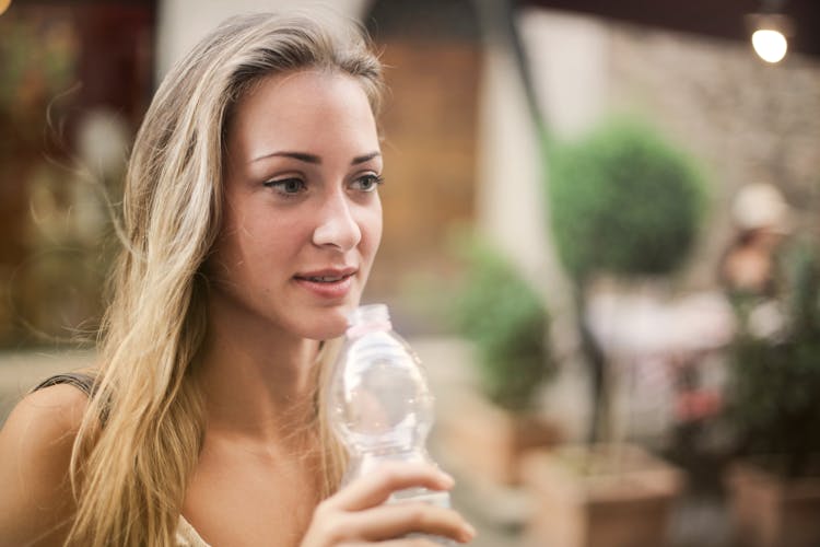 Tranquil Woman Drinking Water On Street