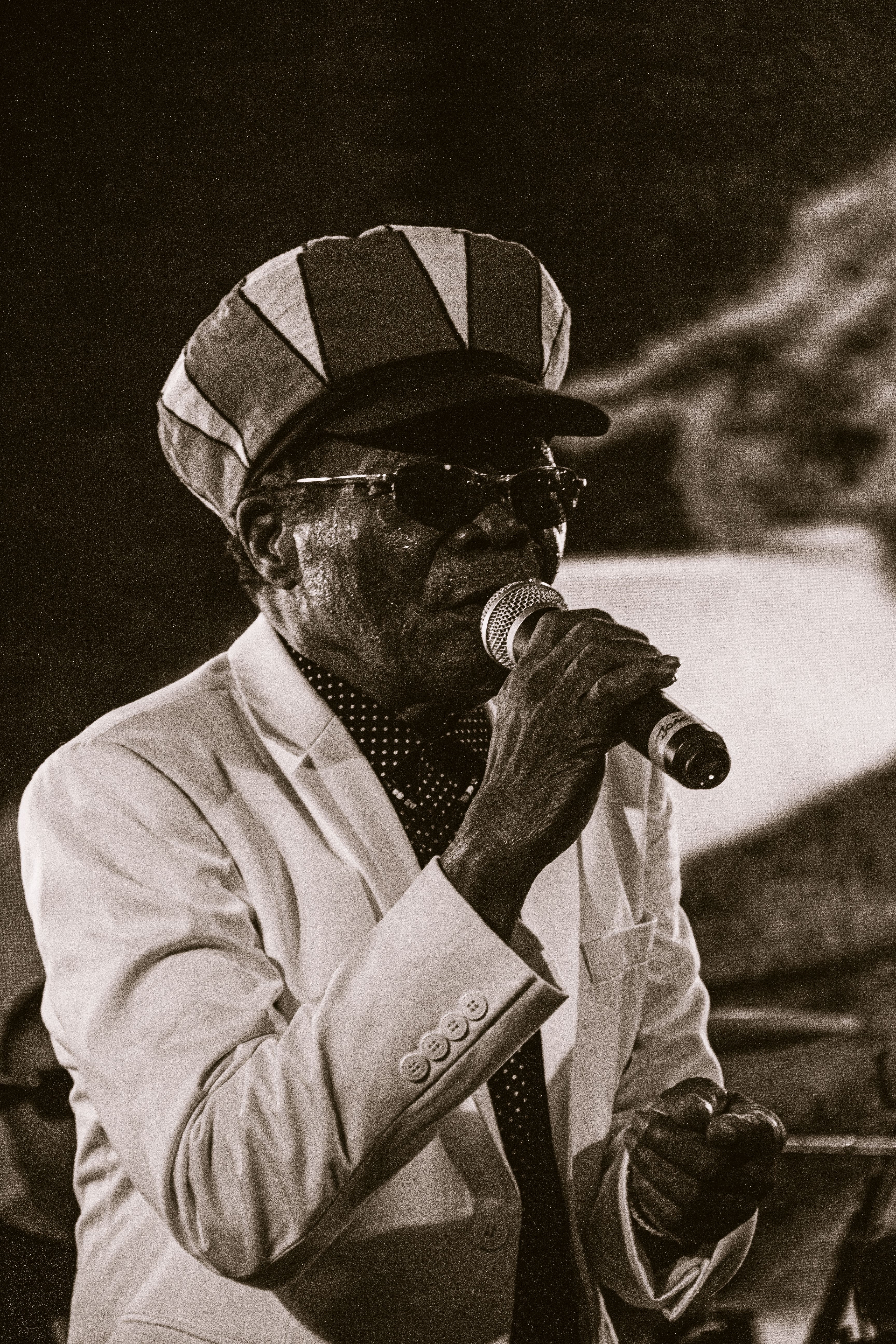 Black and white image of a musician singing on stage in Ceará, Brasil.