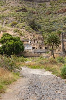 Scenic view of a rustic path leading to stone houses in Las Palmas de Gran Canaria.