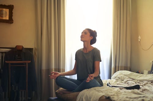 gratis Vrouw Mediteren In Slaapkamer Stockfoto
