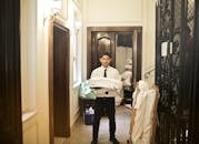 在优雅的走廊里，专业的酒店工作人员拿着新鲜的床单