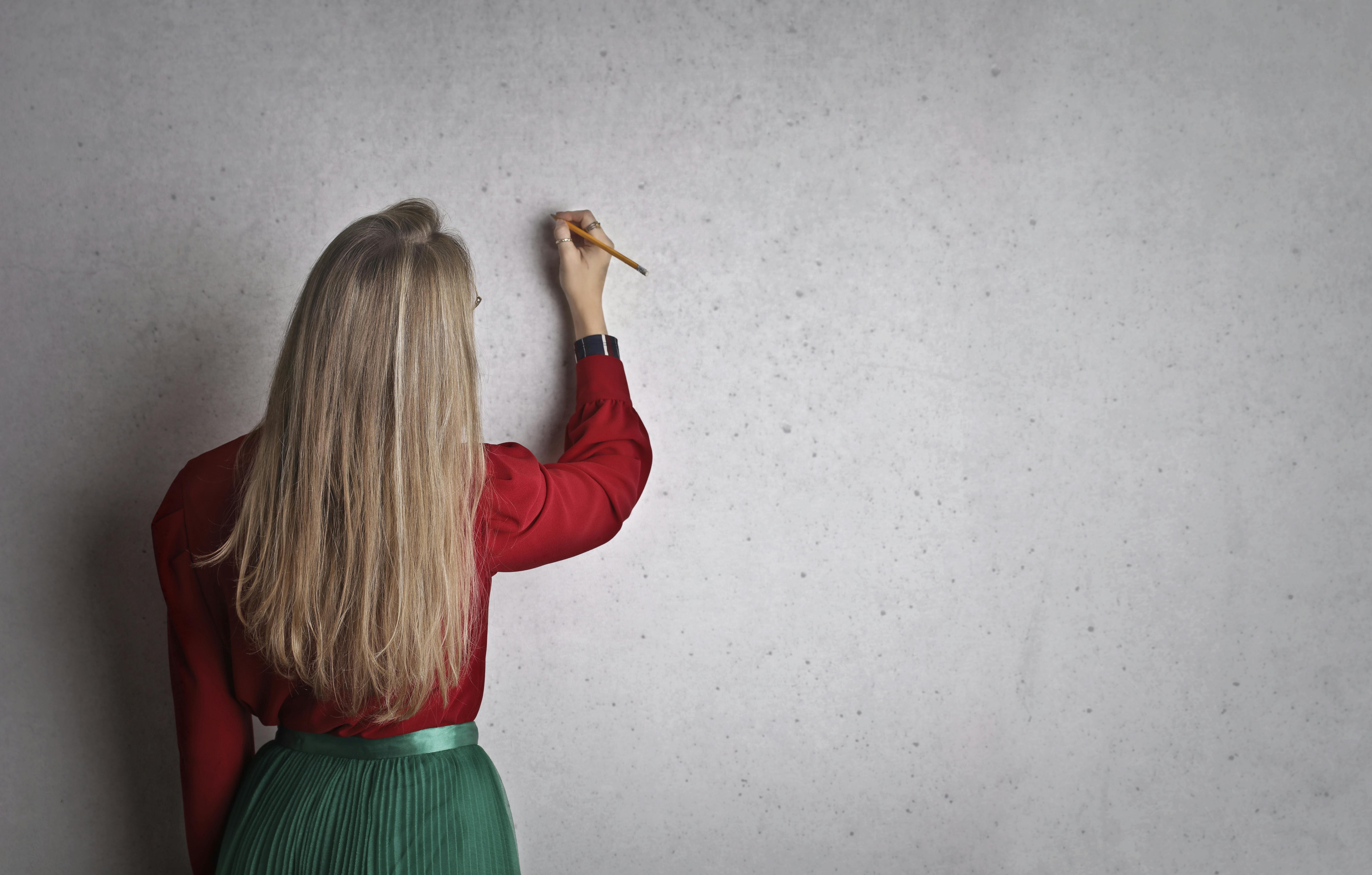 woman taking notes on concrete wall