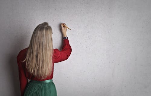 Woman taking notes on concrete wall
