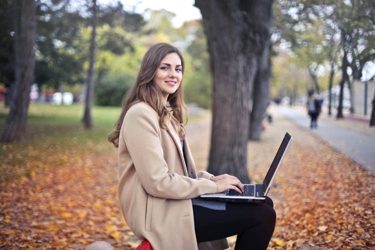 Joyful Confident Woman Using Netbook In Park