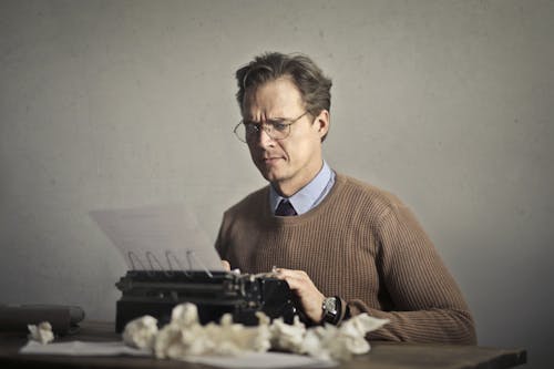 Escritor Adulto Carrancudo Trabalhando Na Máquina De Escrever Em Casa