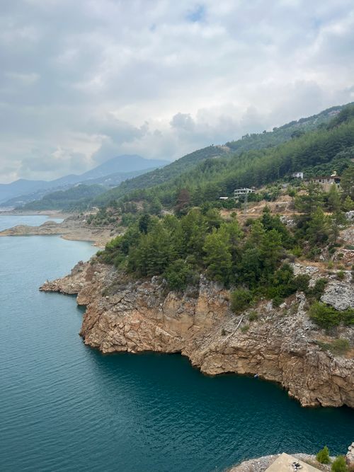 Free Breathtaking view of rocky cliffs by the blue sea under a cloudy sky, perfect for travel and nature imagery. Stock Photo