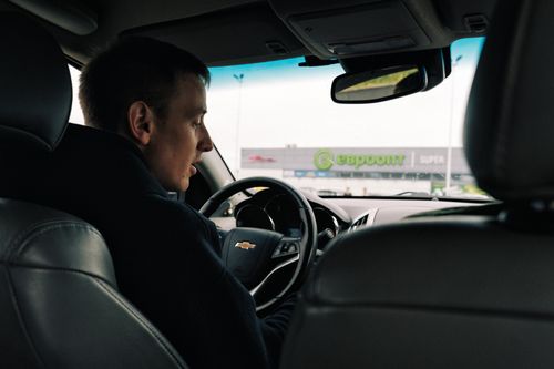 Free View from inside a car with a driver against a backdrop of a shopping center in Novoyelnya, Belarus. Stock Photo