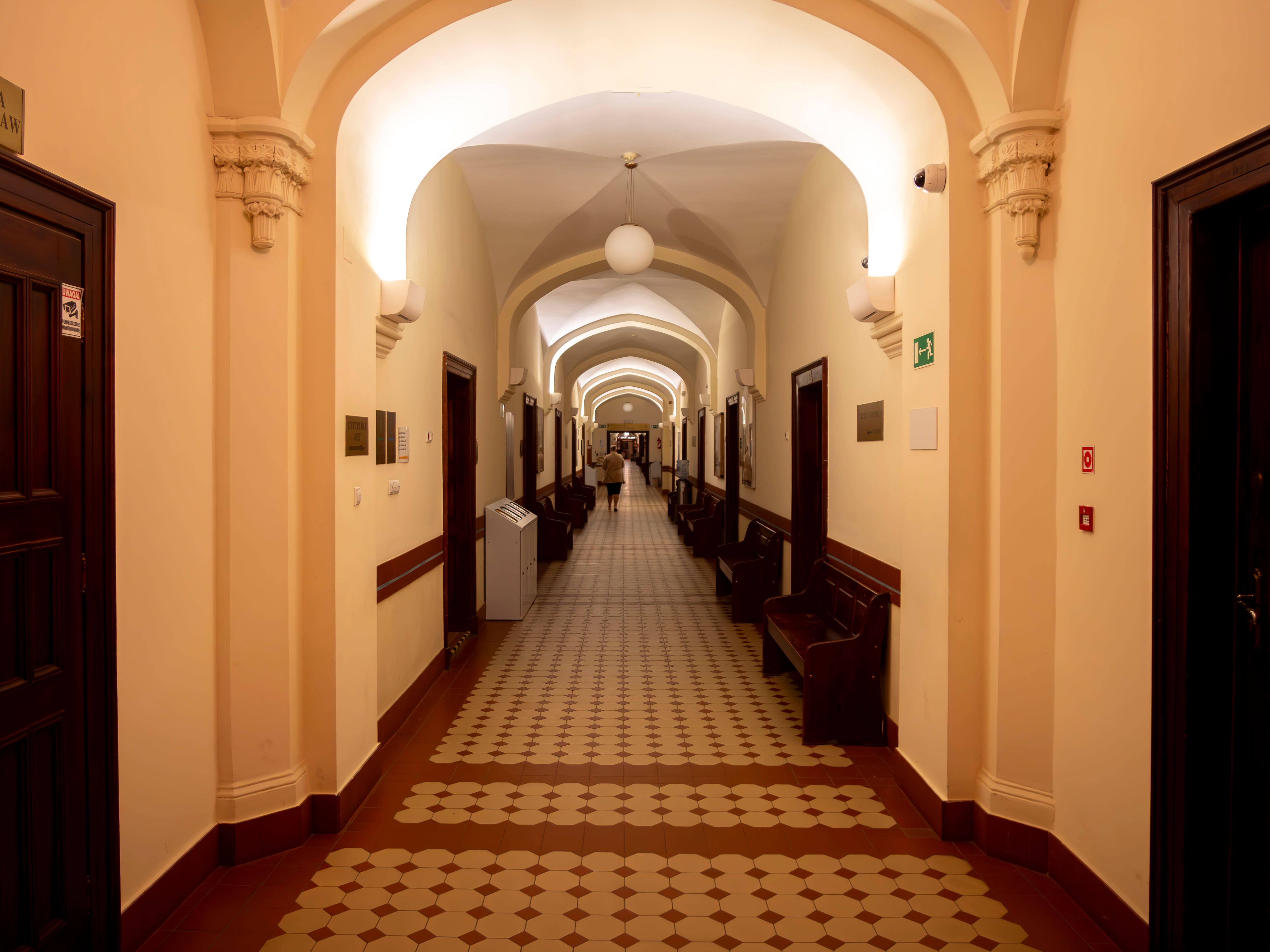 Una antigua sala de tribunal con bancos de madera vacíos con luz tenue