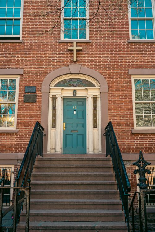 Free Red brick church entrance with a teal door and cross in New York City. Stock Photo