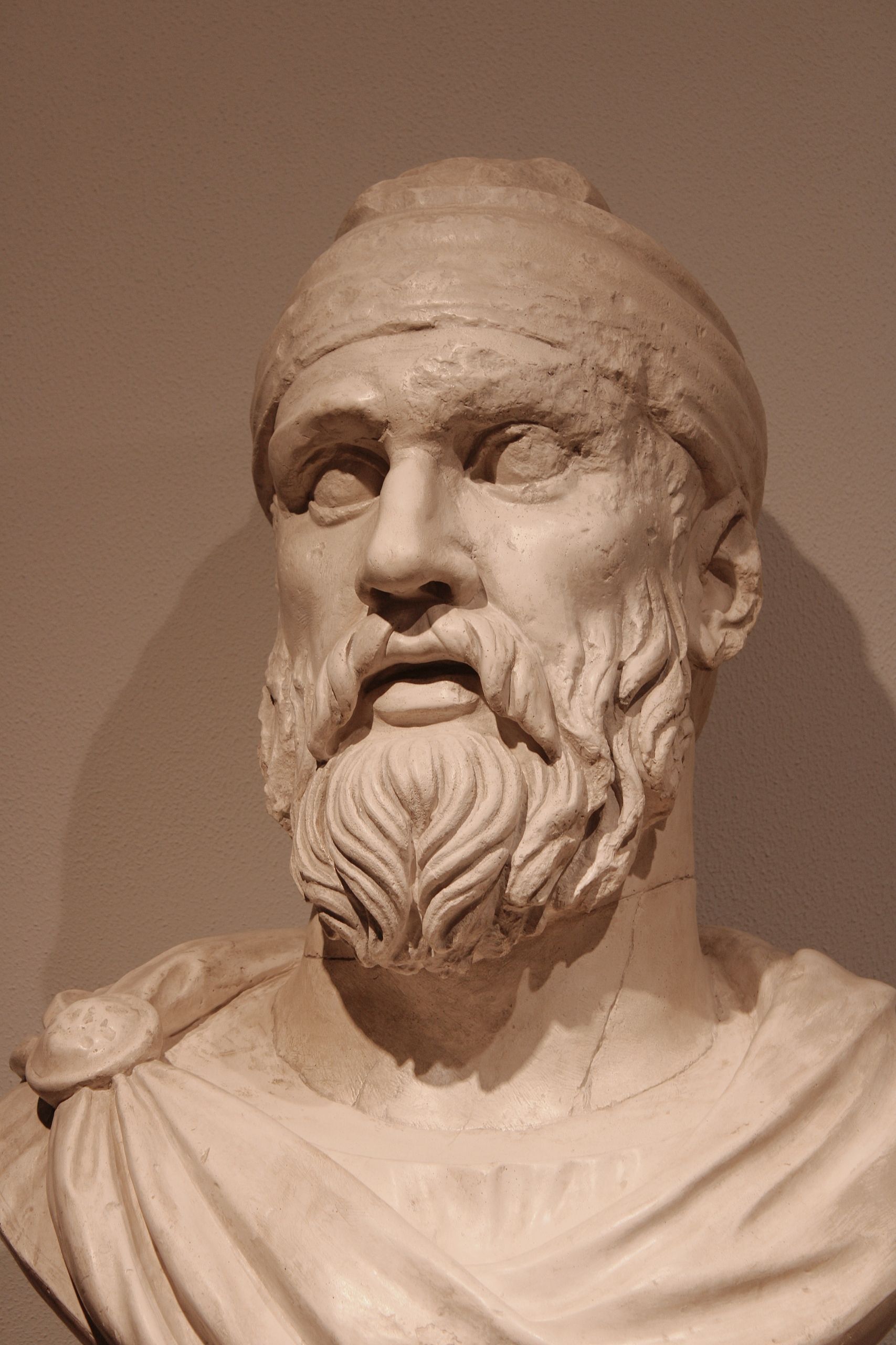 Detailed marble bust of an ancient Greek man with a beard, wearing a headband.
