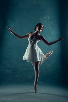Ballet dancer performing an elegant pose in a studio, captured with artistic lighting.
