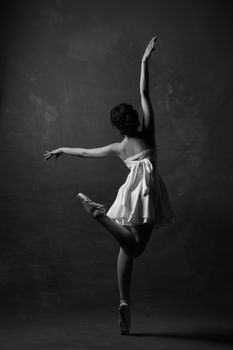 Black and white photo of a ballerina in a graceful pose, showcasing elegance and artistry.