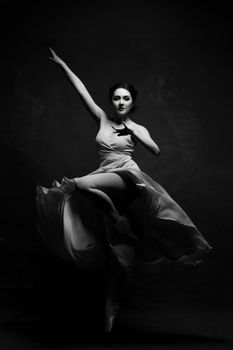 Elegant ballet dancer leaping gracefully in black and white.