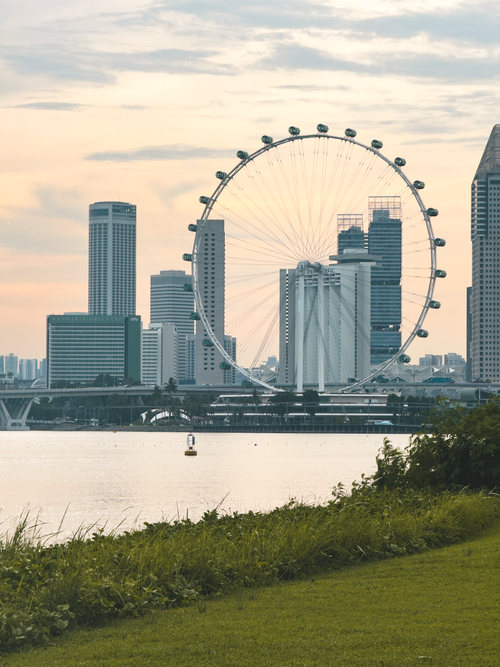 Free Scenic view of Singapore skyline with famous Ferris wheel at dusk. Stock Photo