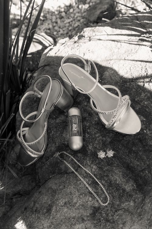 Free Black and white photo of elegant heels and jewelry on a rock outdoors. Stock Photo