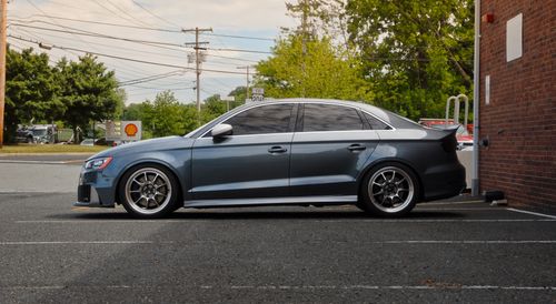 Free Side view of a modern blue sedan in a parking lot with urban background. Stock Photo