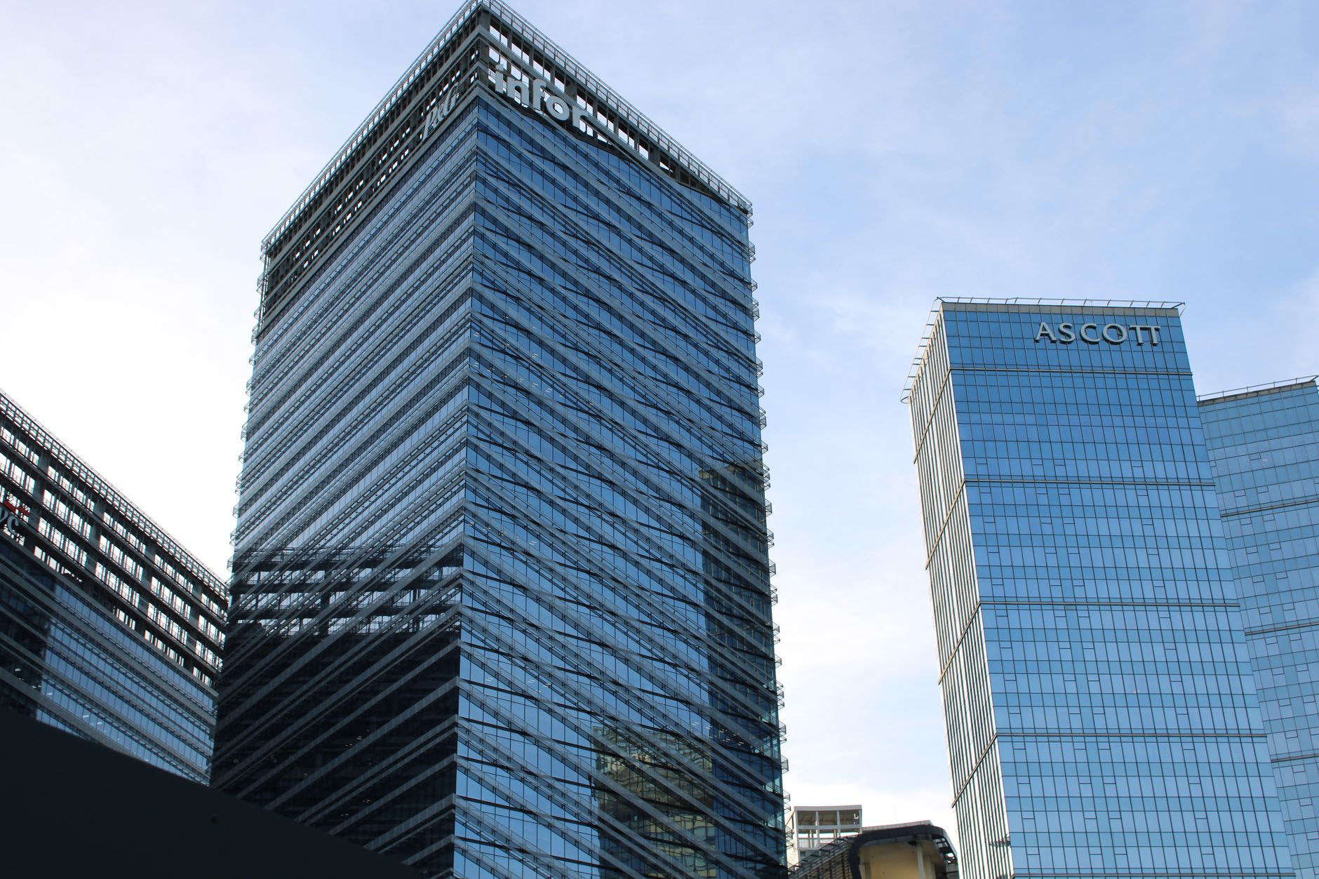 Tall modern glass skyscrapers in Taguig, Metro Manila, under a clear blue sky.