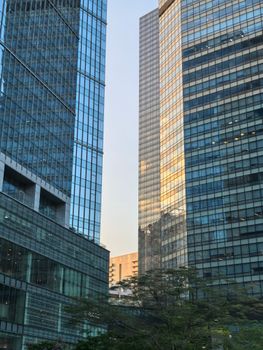 Modern skyscrapers reflecting sunlight at dusk in Taguig, Metro Manila, Philippines.