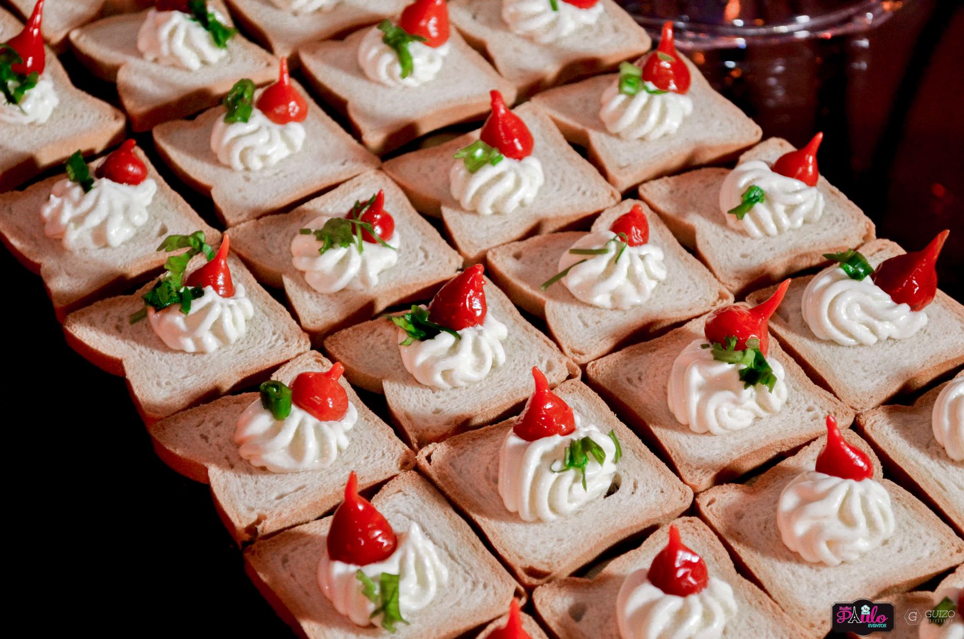 Apetiser gourmet dengan cream cheese dan paprika merah di irisan roti, sempurna untuk pesta atau bufet.