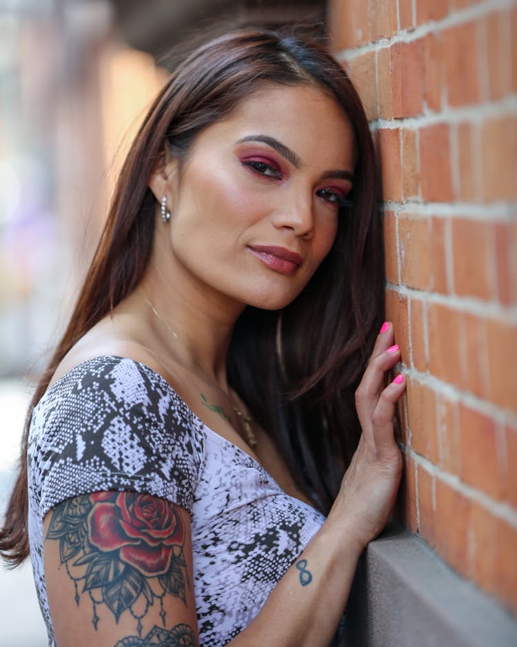 Dreamy Ethnic Woman Leaning On Wall On Street