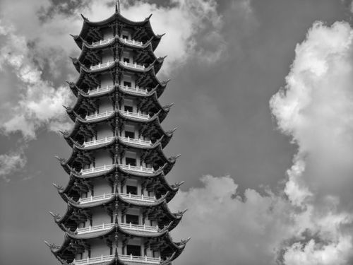 Free A striking black and white photo capturing the intricate details of a traditional pagoda against a cloudy sky. Stock Photo