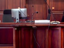 A wooden podium fitted with microphones in a hearing room — photo by SHOX ART on Pexels
