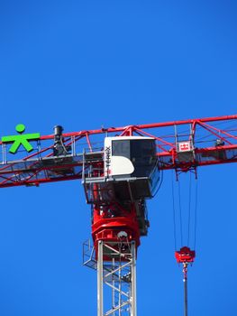 Close-up of a red crane tower with a blue sky background.