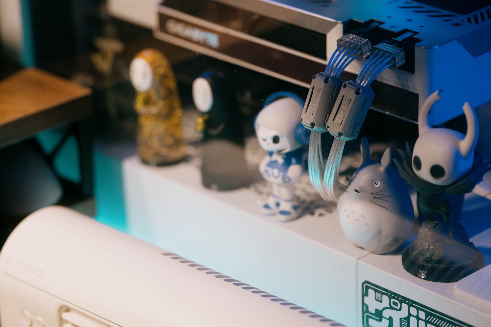 A close-up of toy figurines with a gaming console showcasing vibrant, moody lighting.