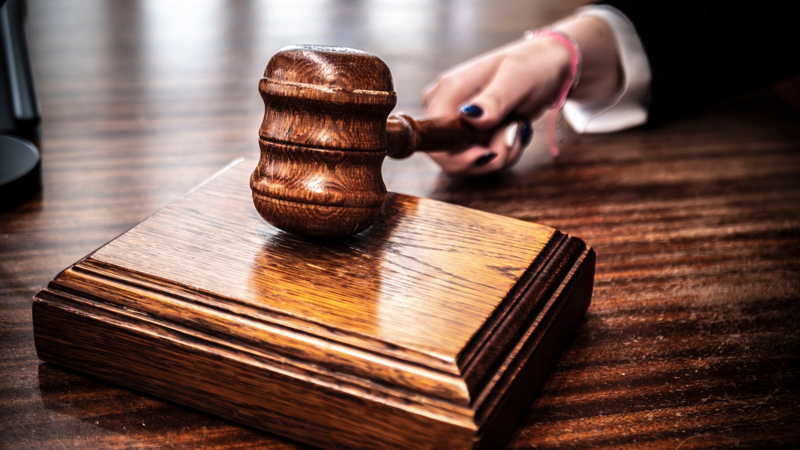 Close-up of a wooden gavel on a judge's desk, symbolizing justice.