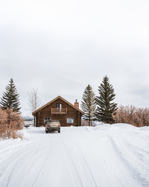 Brown Wooden House on Snow Covered Ground