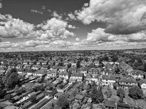 Aerial black and white view of a sprawling suburban neighborhood under a cloudy sky.