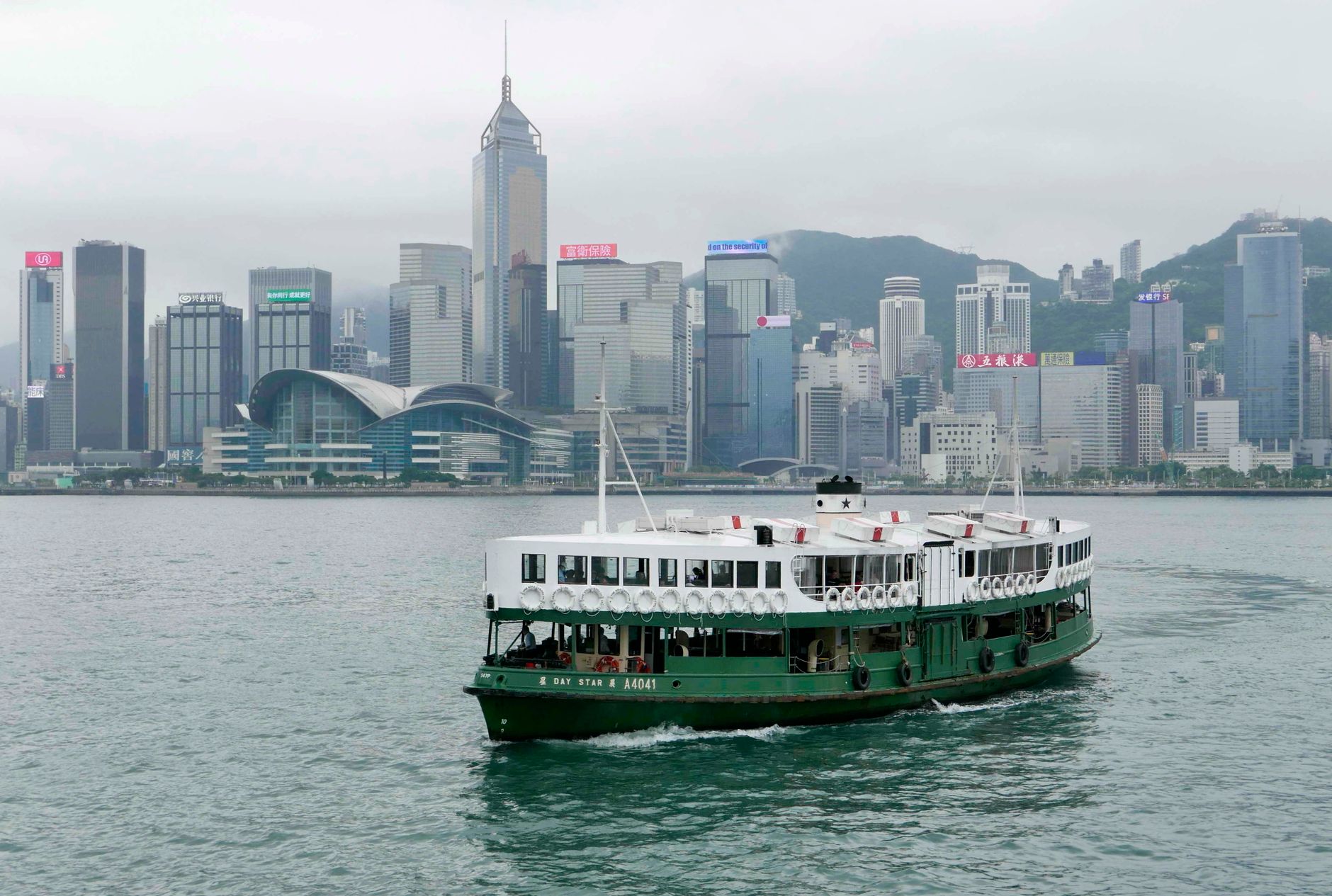 Star Ferry boat cruising across Hong Kong's Victoria Harbour with the skyline in the background.