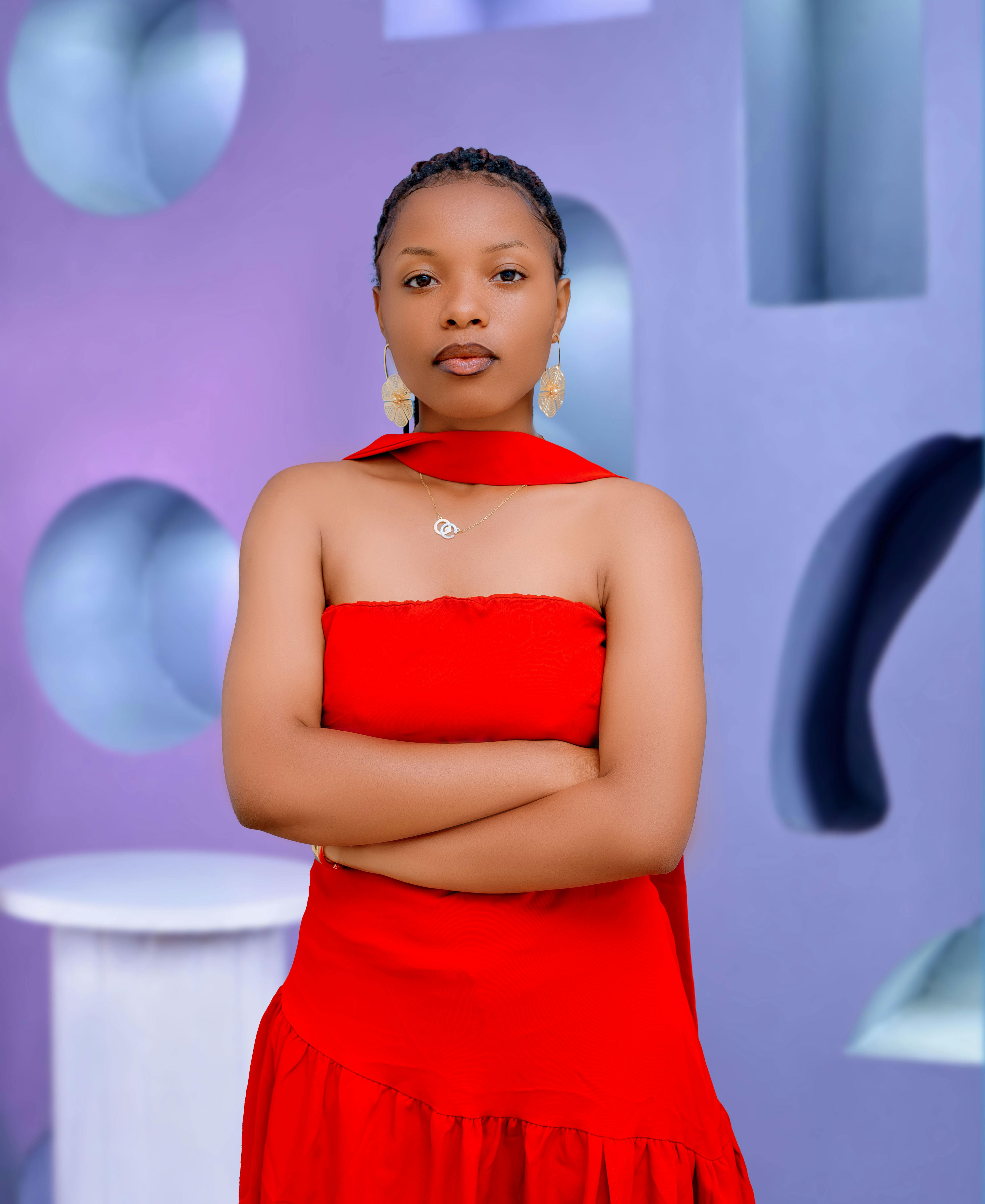 Elegant woman in a red dress posing confidently against a modern abstract background.