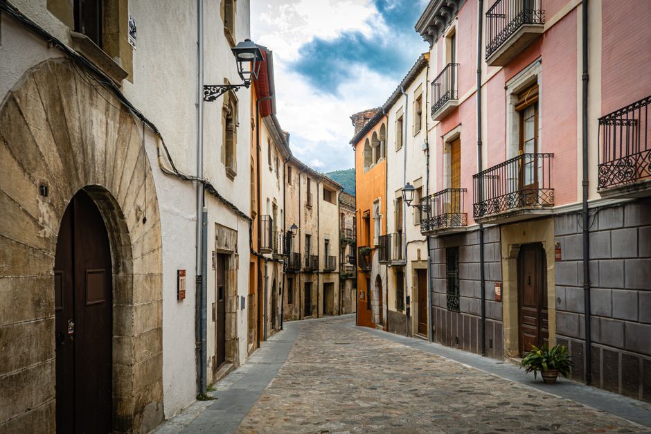 A picturesque narrow alley in a European village with colorful buildings and cobblestone street.