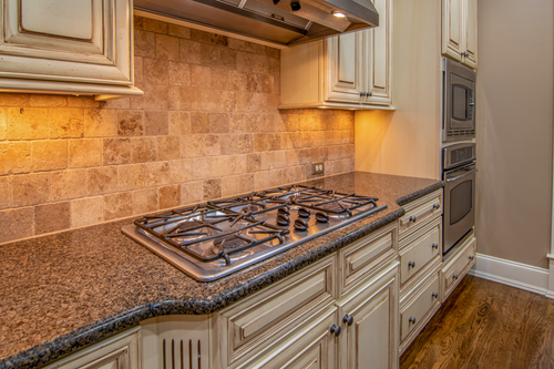 Free Elegant kitchen featuring granite countertops and stainless steel appliances. Stock Photo