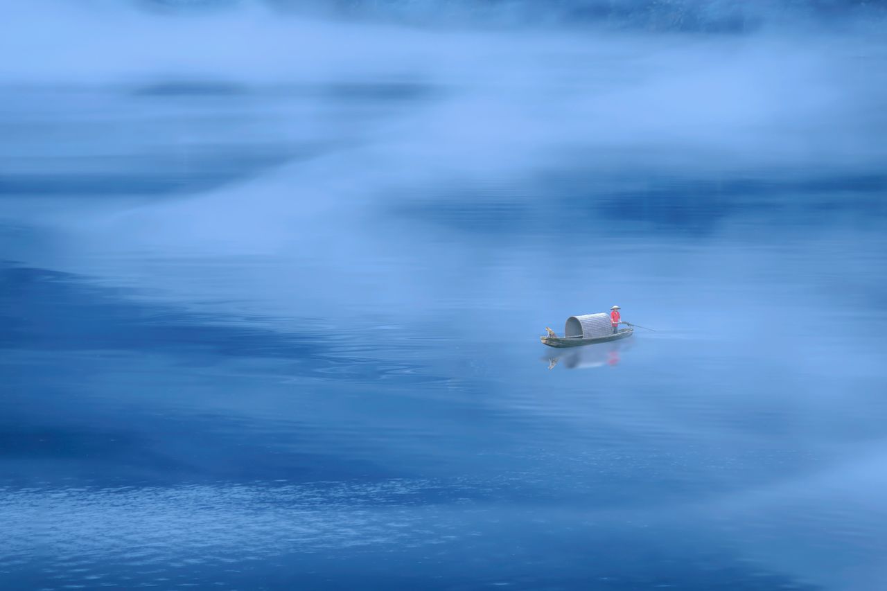 a solitary boat navigates through misty waters on a serene lake in hun