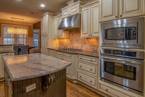 Free Silver Microwave Oven on Brown Wooden Kitchen Cabinet Stock Photo