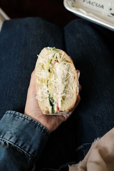 A person holding a tasty sandwich filled with fresh ingredients and cheese.
